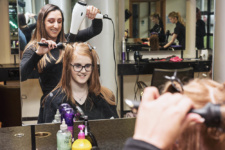 Female hairdressing student gives client blow dry limavady campus
